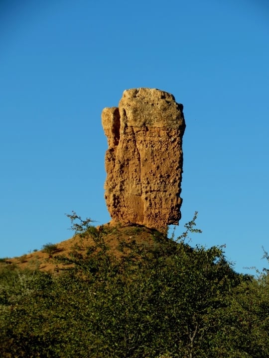 The towering sandstone Vingerklip stands like a finger pointing skyward against a clear Namibian sky