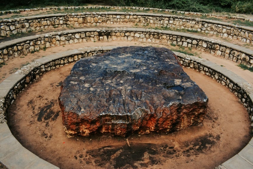 Rough, dark metallic surface of the Hoba meteorite showing texture, dents, and natural weathering from years on Earth.
