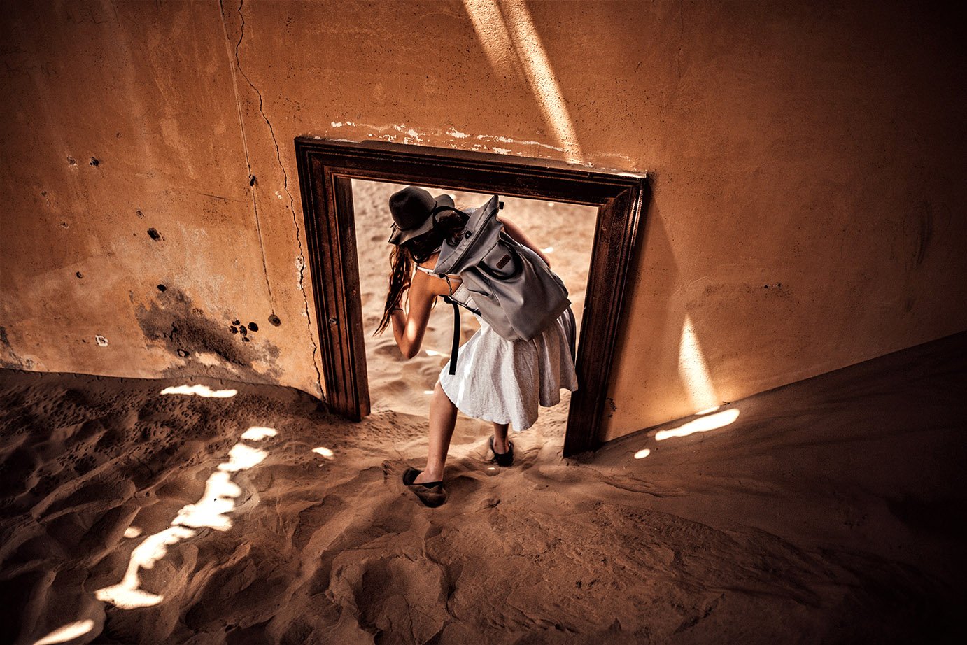 Deserted buildung, sand filled room and door frame, Kolmanskop, Namibia