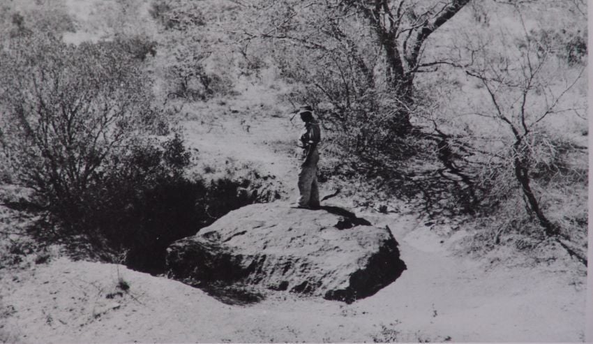 Dated photo of man standing on Hoba meteorite in Otjozondjupa Region. 
