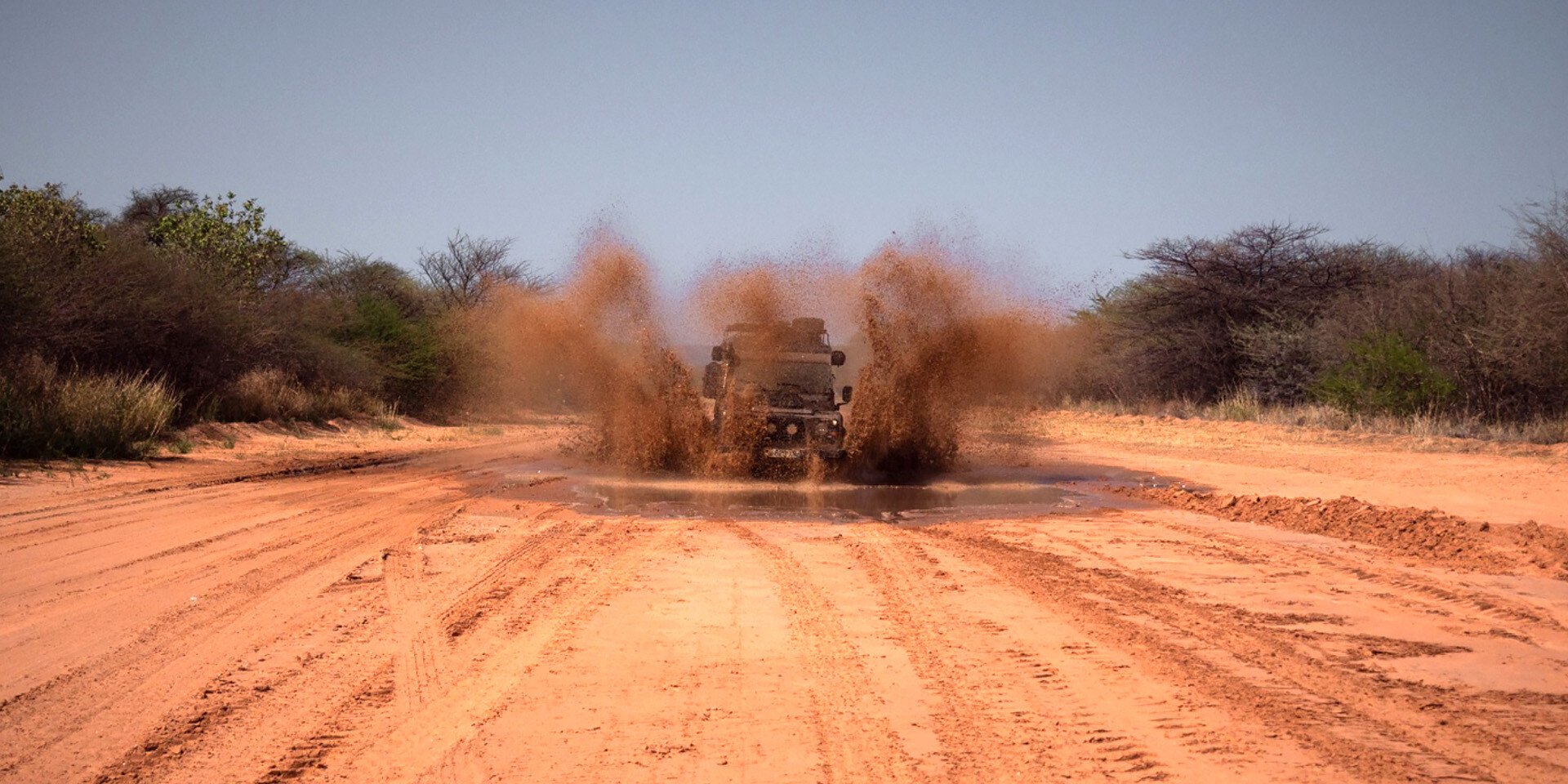 Car driving through mud pool, Namibia